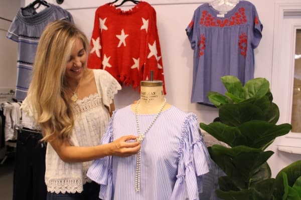Head merchandiser Lauren Oliver styles a mannequin. (Olivia Lueckemeyer/Community Impact Newspaper)