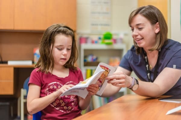 Communication disorders graduate student Karen Brackett helps 7-year-old Bonnie Choate with phonics skills at the Read to Succeed camp at the Callier Center for Communication Disorders. (Courtesy UT Dallas)