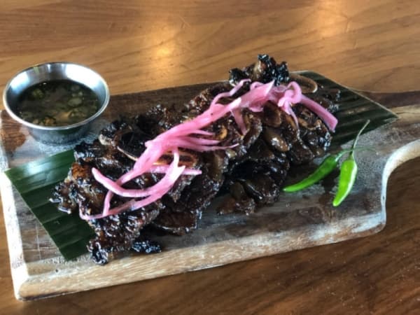 Filipino BBQ: $14•Beef short rib is marinated in a secret sauce and served with spicy vinegar and pickled red onion.