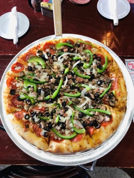 The Godfather Supreme ($20) at Wise Guys Pizzeria comes with red sauce, pepperoni, Italian sausage, meatballs, olives, mushrooms, green bell peppers, onions and mozzarella. (Ian Pribanic/Community Impact Newspaper)