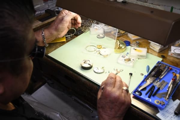 Homero Capetillo analyzes a broken-down timepiece at his shop.  (Hunter Marrow/ Community Impact)