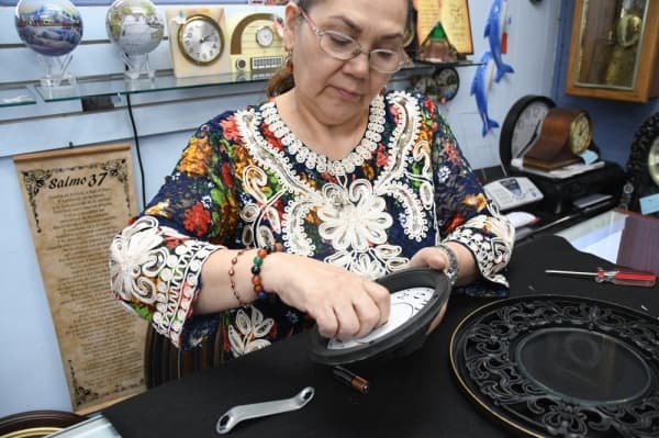 Adelaida Capetillo removes the hands from a clock she is repairing.(Hunter Marrow/ Community Impact)