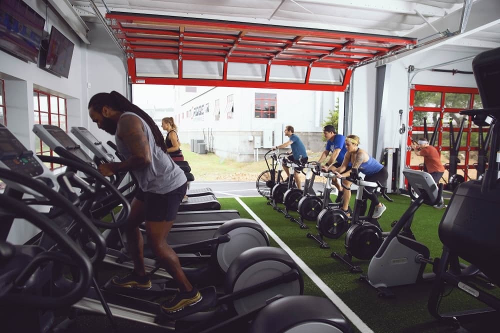 A photo of several people exercising on cardio exercise machines.