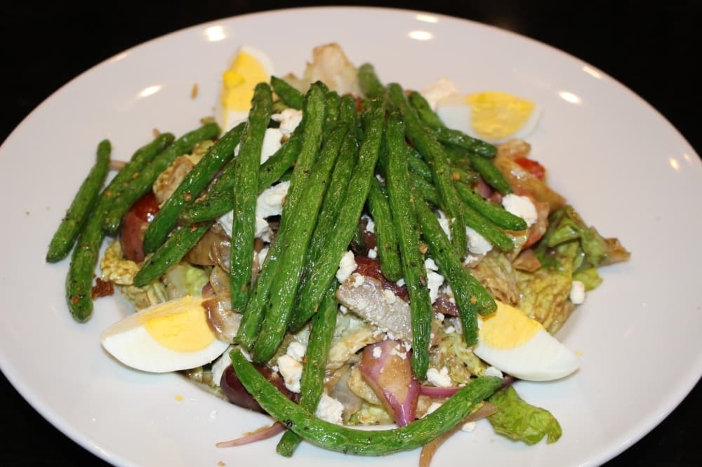 The farmers garden salad on romaine lettuce features potatoes, tomatoes, olives, red onion, egg and green beans and is available with optional protein additions ($10). (Ben Thompson/Community Impact Newspaper)