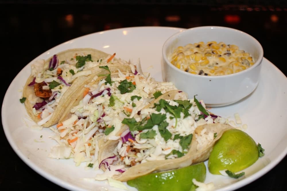 The blackened shrimp tacos feature a trio of corn tortillas packed with shrimp, cabbage, queso fresco and cilantro ranch dressing along with a signature side ($14). (Ben Thompson/Community Impact Newspaper)