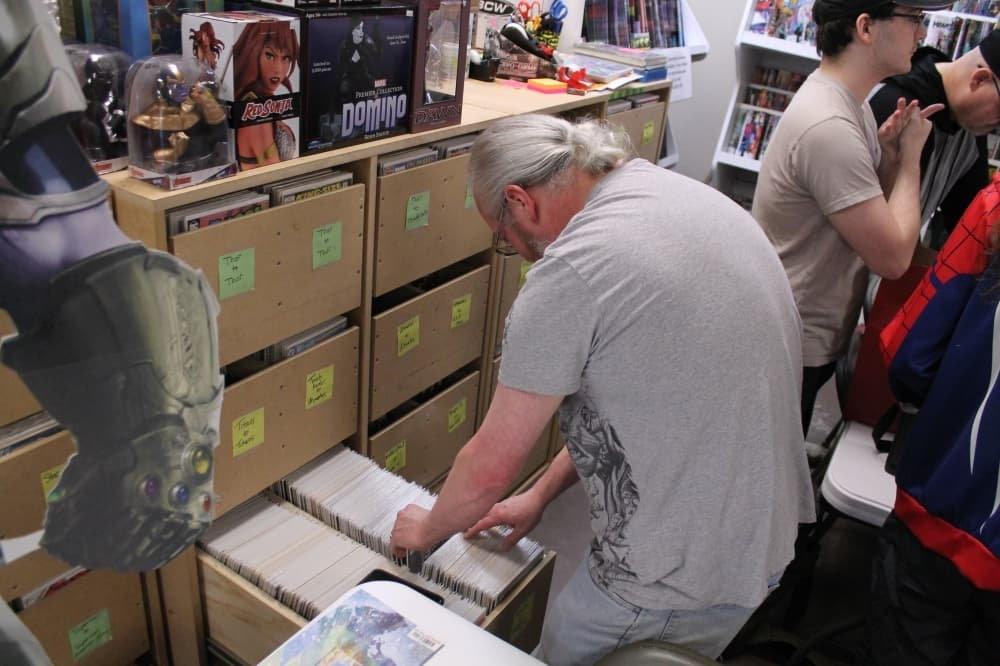 A customer sorts through the drawers of Besaw’s personal comic book collection. (Photos by Lindsey Juarez Monsivais/Community Impact Newspaper)