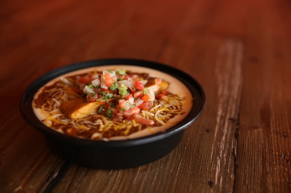 The Tommy Bowl ($7 one tamale, $9 two tamales) includes a choice of tamale with beef chili, queso, pico and rice. It is also covered in cheese. (Photos by Liesbeth Powers/Community Impact Newspaper)