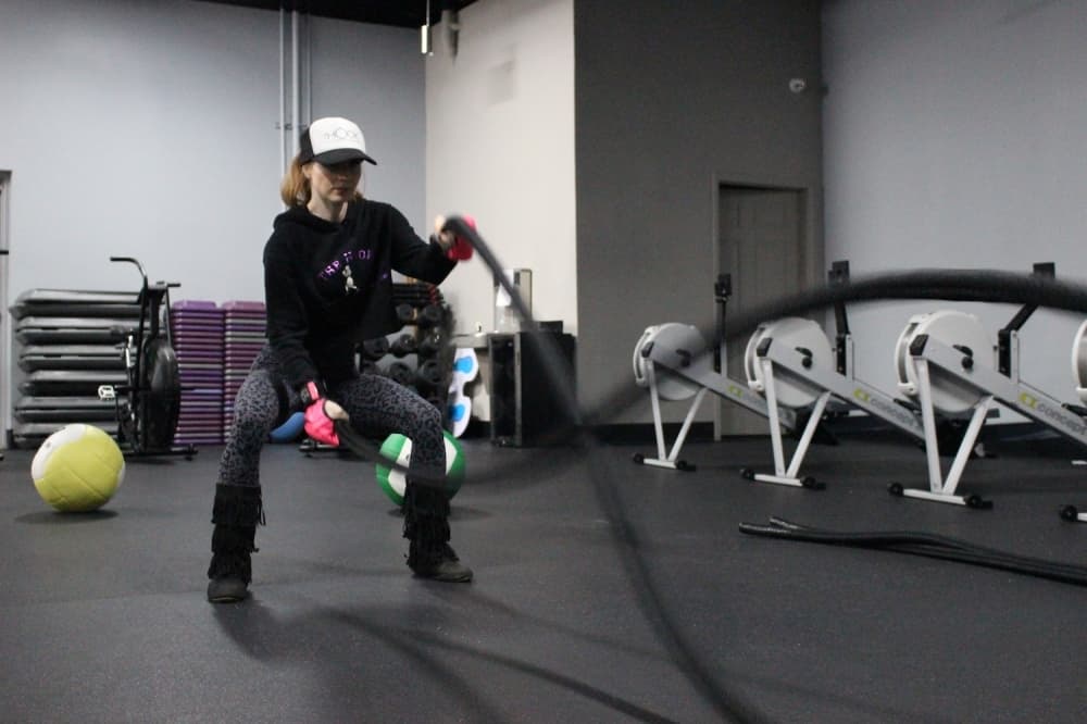 Battle ropes can be used in multiple ways. One way is pumping your arms to form alternating waves. (Renee Yan/Community Impact Newspaper)