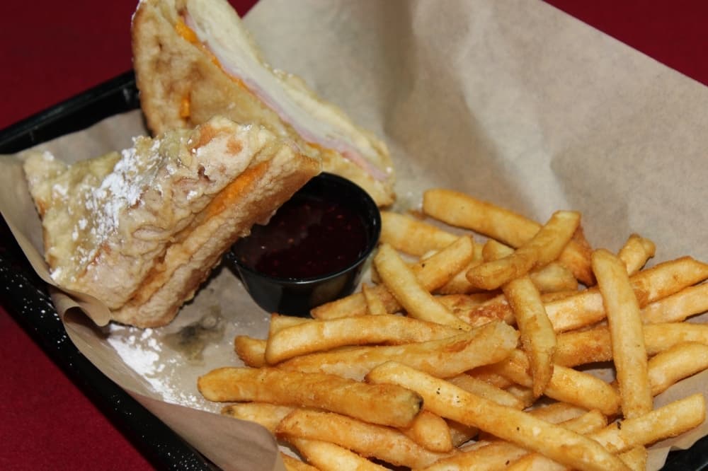 The Monte Cristo ($10.99) is a deep-fried, ham and cheese French toast sandwich topped with powdered sugar and served with a side of raspberry preservatives. (Adriana Rezal/Community Impact Newspaper)