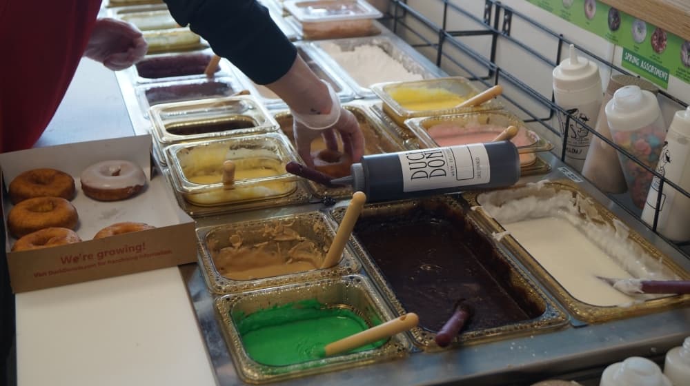 Customers can pick individual icings and toppings to add to their vanilla cake doughnut base. (Kelsey Thompson/Community Impact Newspaper)