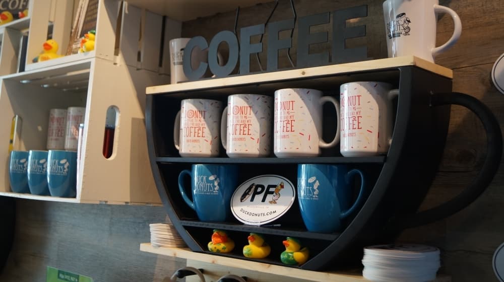 Outside of its food and drink sales, Duck Donuts also has commemorative items available to customers for purchase. (Kelsey Thompson/Community Impact Newspaper)