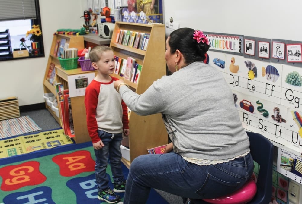 Pre-K teacher Sarah Rivera assigns responsibilities to different students each day. Using an imaginary microphone Feb. 19, she interviews that day's "weatherman' who is giving a weather report after looking out the classroom window. (Brian Perdue/Community Impact Newspaper)