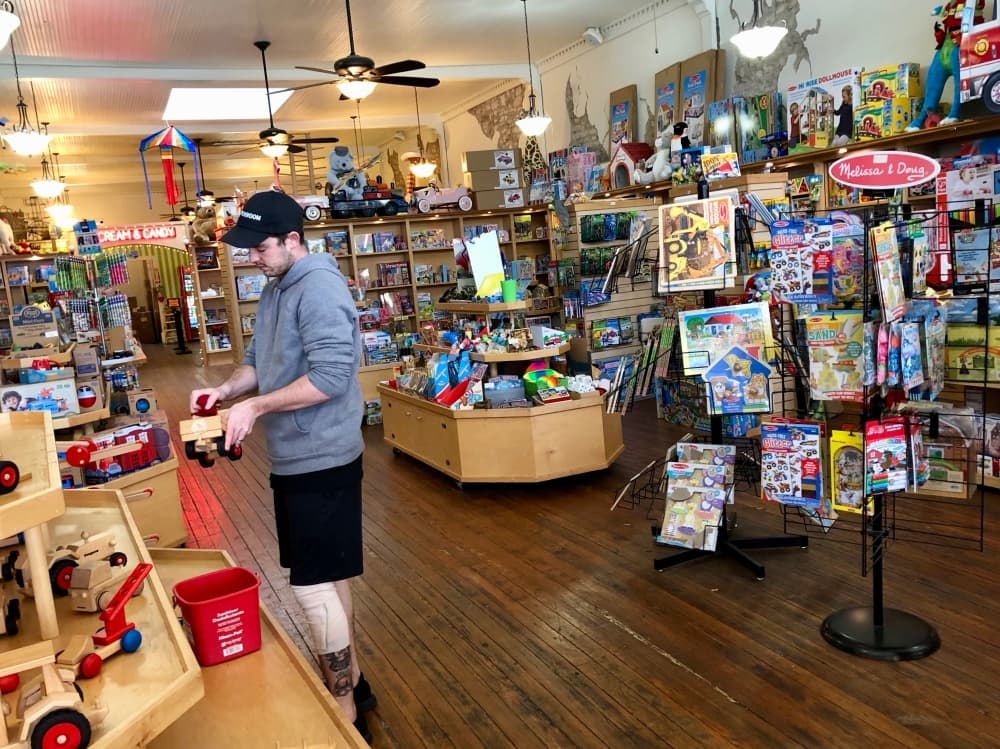 Forest Homderding wipes down toys in an empty All Things Kids on March 16. (Sally Grace Holtgrieve/Community Impact Newspaper)