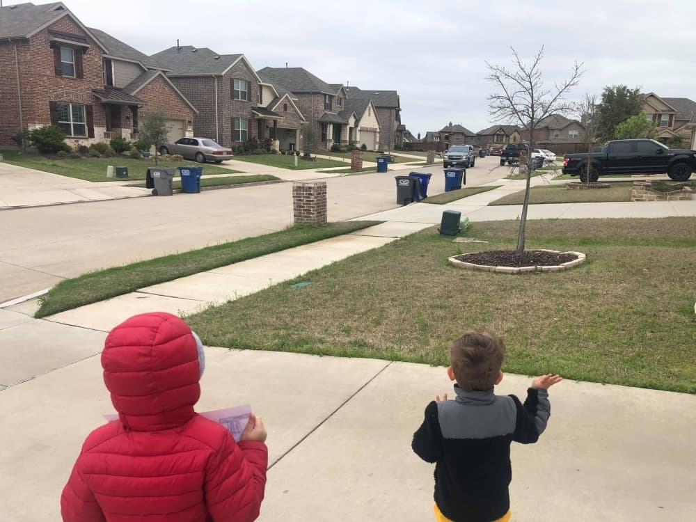 Two students watch the car parade from the driveway of their home. (Courtesy Heather Kestila)