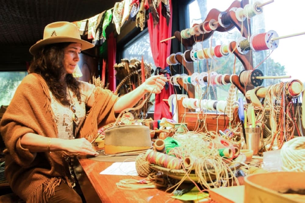 Heather Welborn of Aspen Hatter chooses materials to finish a custom-made hat. This band is made out of fabric from a dress.(Jack Flagler/Community Impact Newspaper) 