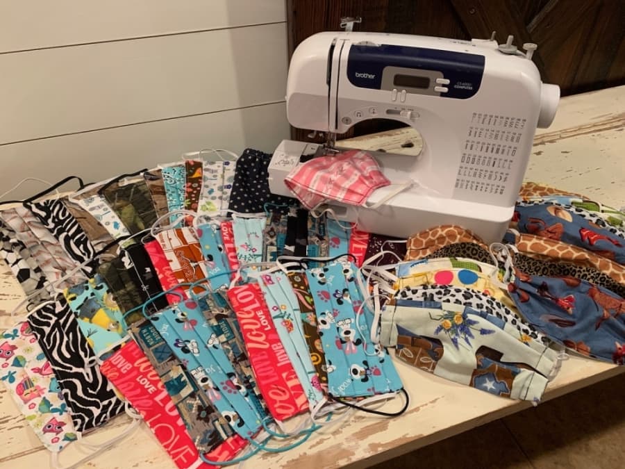 A photo of hand-sewn masks laid out next to a sewing machine
