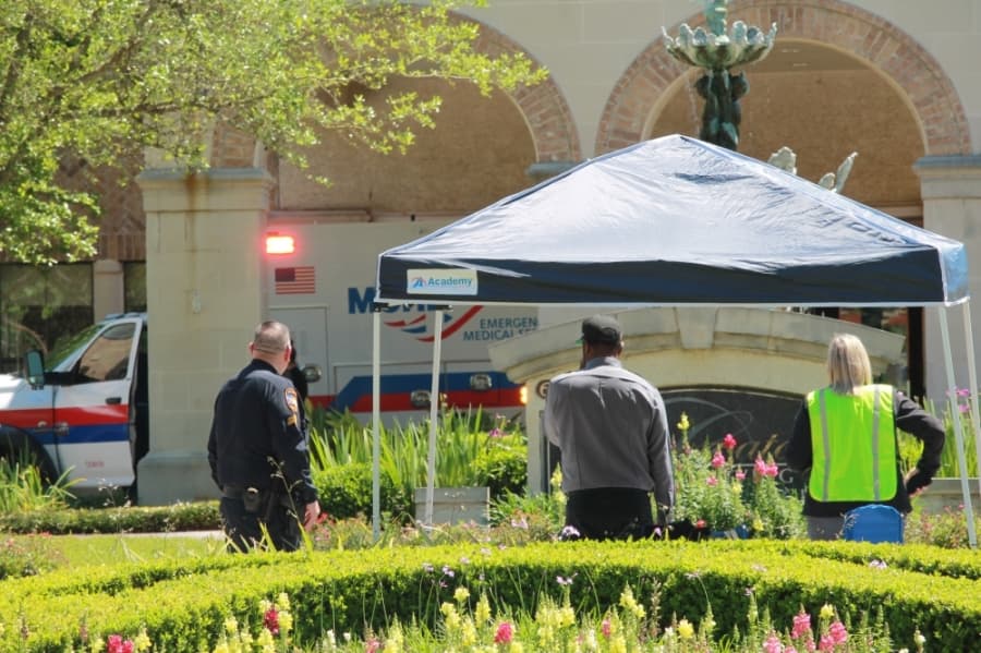 Onlookers watch as paramedics arrive at the Conservatory at Alden Bridge on March 31. (Andy Li/Community Impact Newspaper)