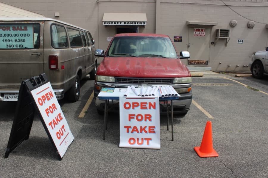 At Rocket Banners on Ben White Boulevard, "open for take out" signs are available for restaurant owners to pick up. (Christopher Neely/Community Impact Newspaper)