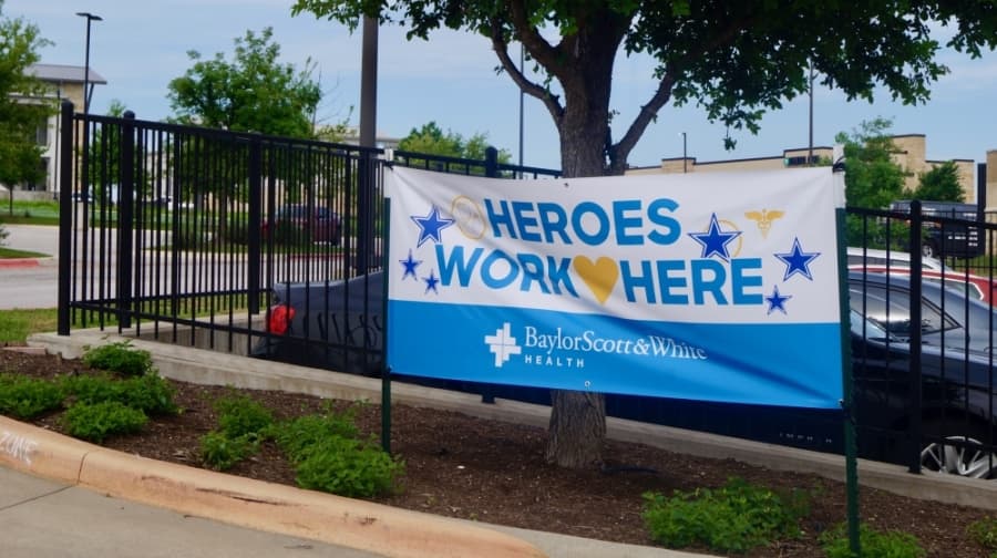 Outside Baylor Scott & White Clinic — Pflugerville, a sign reads "heroes work here." (Kelsey Thompson/Community Impact Newspaper)