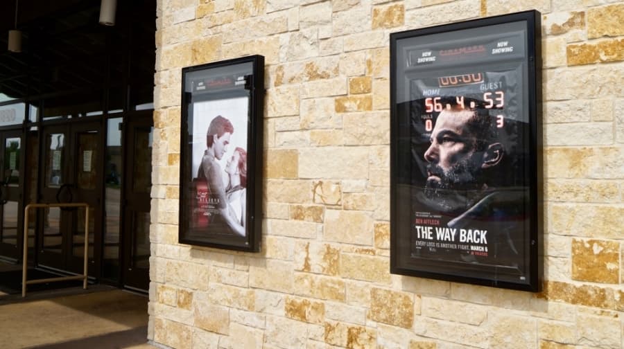 Promotional movie posters outside of Cinemark advertise movies that premiered in March, prior to Travis County's shelter in place orders. (Kelsey Thompson/Community Impact Newspaper)