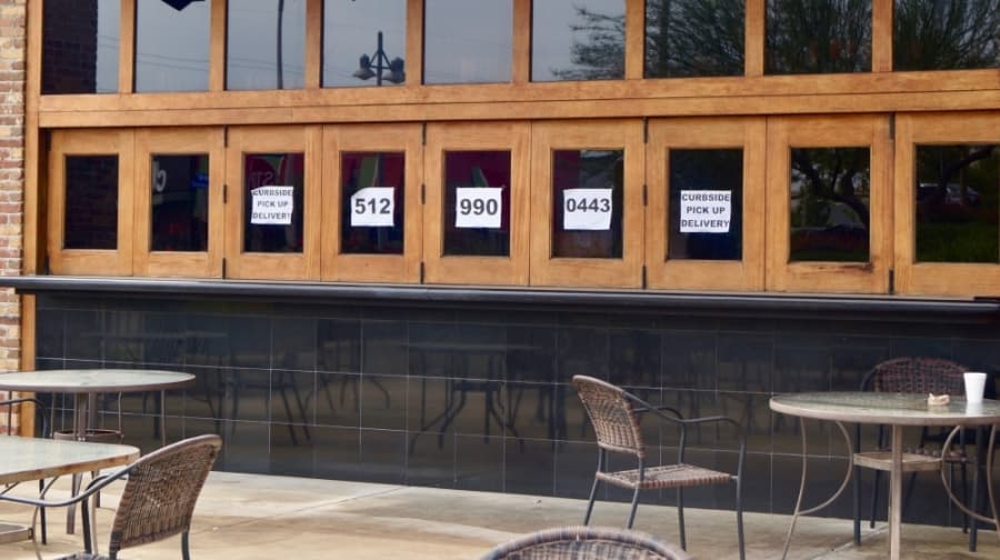 Shogun Japanese Grill & Sushi Bar promotes curbside pickup and delivery services through posted signs on the exterior of its building. (Kelsey Thompson/Community Impact Newspaper)