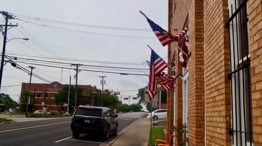 American flags hang in the middle of an empty downtown April 7. (Kelsey Thompson/Community Impact Newspaper)