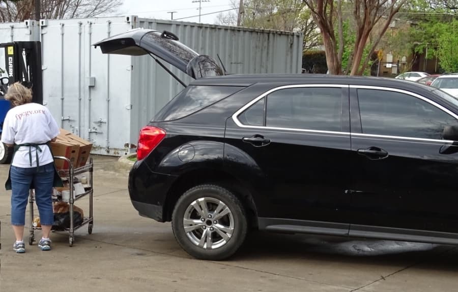 A GRACE worker loads a car with food pantry items. (Courtesy GRACE)