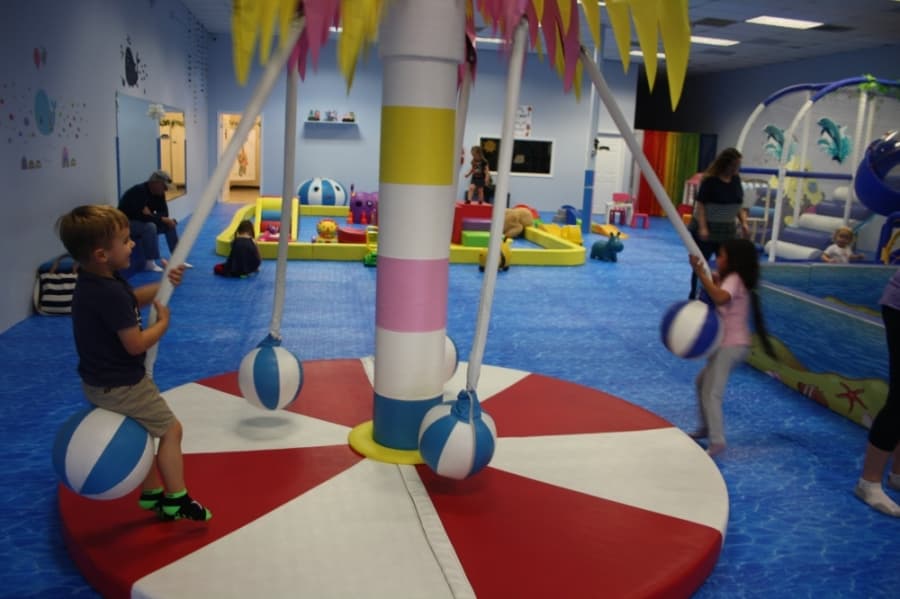 




Children swing on a rotating palm tree swing at the island-themed Fun N Play Indoor Playground.