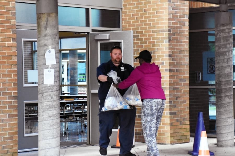 Parents are met by staff at the cafeteria doors to maintain social distancing. (Makenzie Plusnick/Community Impact Newspaper)