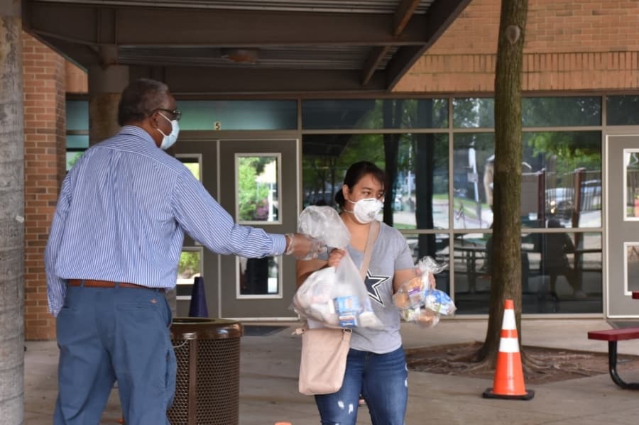 Some parents picking up meals chose to wear masks and other protective gear. (Makenzie Plusnick/Community Impact Newspaper)