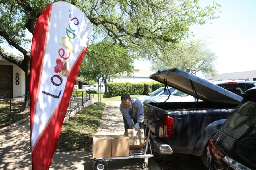 Eric Smith, a P.E. teacher at McCall Elementary, loads packed boxes into his truck, preparing to deliver close to 28 boxes to students in need from his school. (Liesbeth Powers/Community Impact Newspaper)