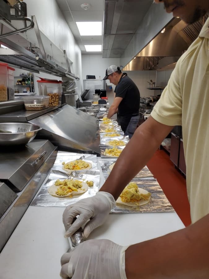 Toasted Yolk employees prepare trays of free breakfast tacos for local health care workers at two Memorial Hermann locations in the Katy area. (Courtesy Toasted Tolk)