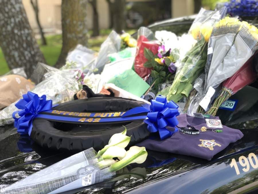 Residents, family and friends leave notes, flowers and other items to show tribute to the fallen police officer, Justin Putnam. (Evelin Garcia/ Community Impact Newspaper)