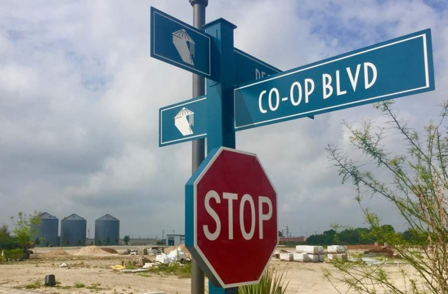 With construction deemed an essential business, work progresses on the Co-Op District. The installation of wayfinding signage, landscaping and building construction was underway April 21. (Taylor Jackson Buchanan/Community Impact Newspaper)