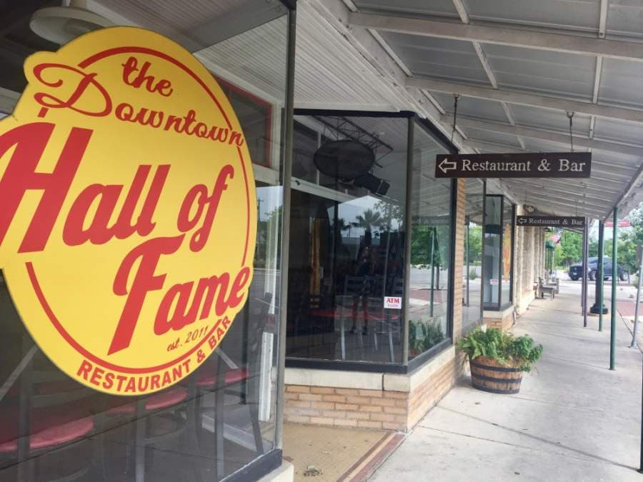 Tables and chairs are stacked against the windows inside The Downtown Hall of Fame. The dine-in portion of the restaurant is temporarily closed per state mandate, but customers can order food for delivery and takeout at this time. (Taylor Jackson Buchanan/Community Impact Newspaper)