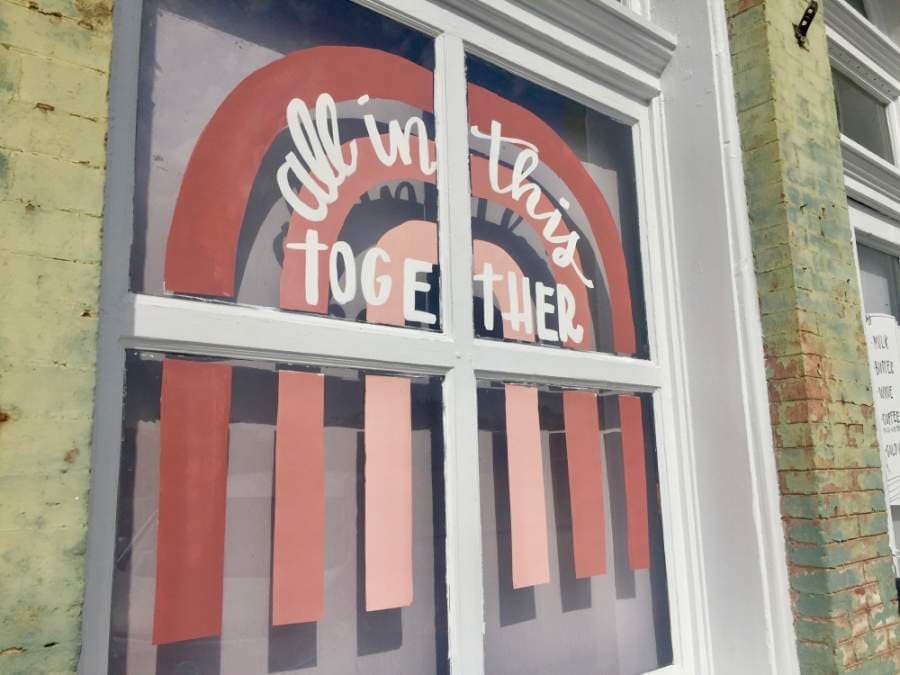 A message painted on the windows of East Social House reads "all in this together." (Taylor Jackson Buchanan/Community Impact Newspaper)