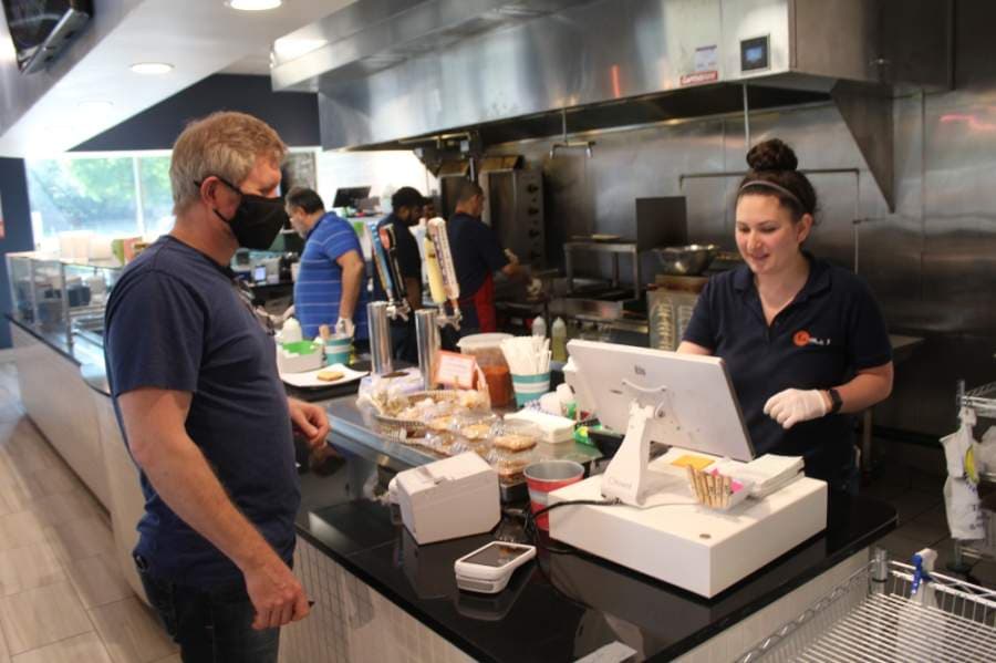 Cedar Park resident Tai Hoernke picks up a takeout order April 20. (Brian Perdue/Community Impact Newspaper)