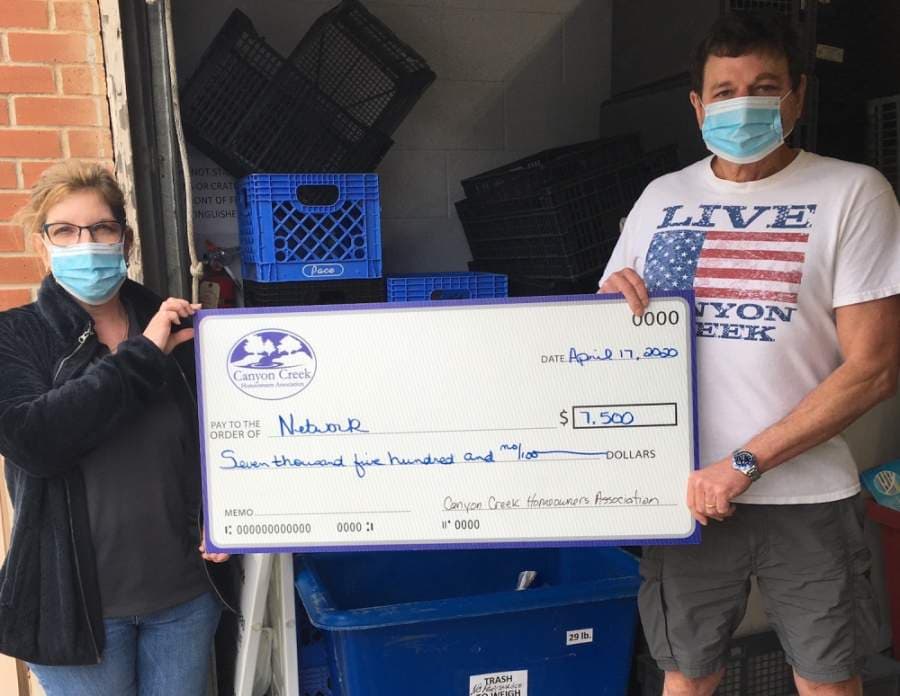 From left: Network CEO Cindy Shafer accepts a check for $7,500 from Canyon Creek HOA president Warren Caldwell. (Courtesy Warren Caldwell)