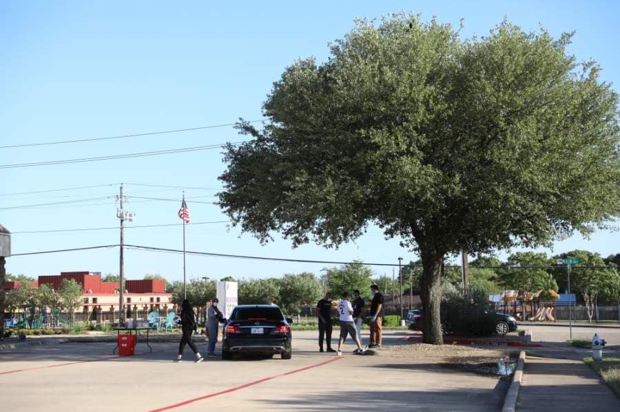 Drivers were able to pick up coupons and food within the parking lot and along the street of Allen Community Outreach. Volunteers stood along the street and in the parking lot with signs to let drivers passing by that free food was available. (Liesbeth Powers/Community Impact Newspaper)