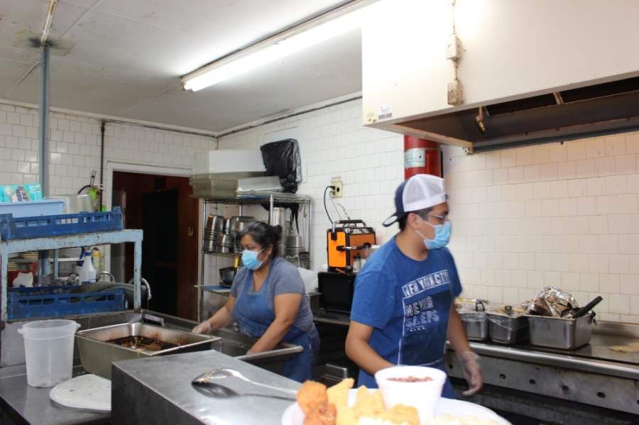 The staff at Bill Smith's Cafe wear masks as they prepare food. (Miranda Jaimes/Community Impact Newspaper)