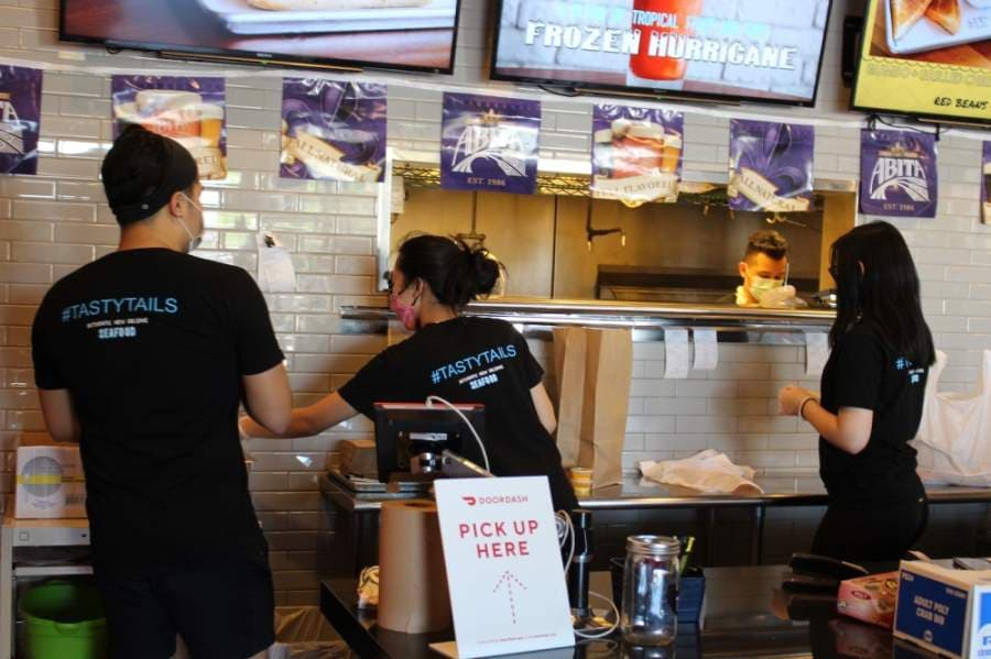 Employees at Tasty Tails bag items for takeout. The restaurant has decided not to reopen for the time being, manager Khang Go said. (Olivia Lueckemeyer/Community Impact Newspaper) 