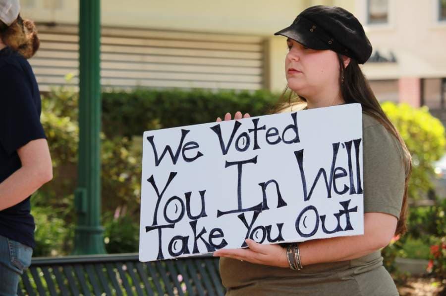 Many speakers urged protestors to vote out elected officials who were implementing restrictions. (Andy Li/Community Impact Newspaper)