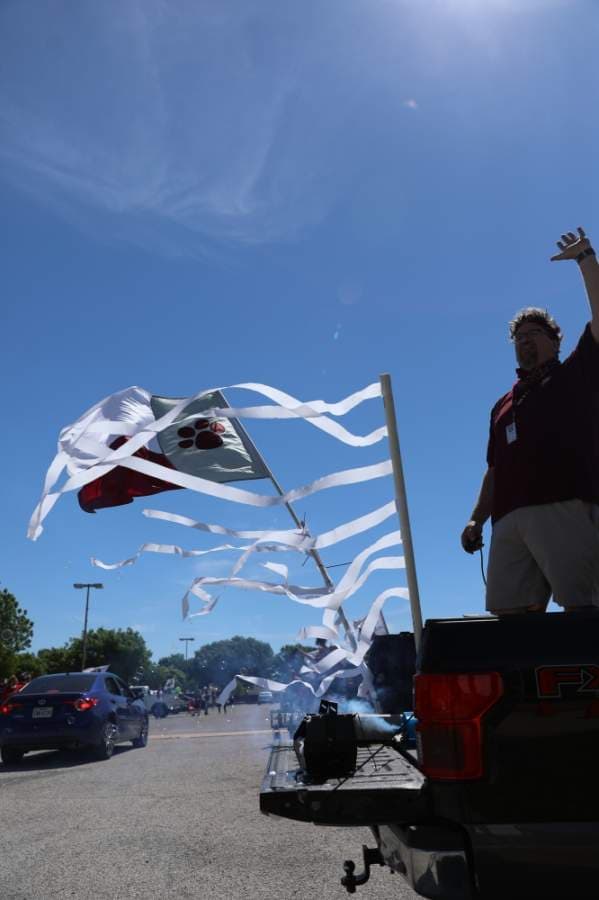 Matt Cone, American Studies teacher at Plano Senior High School, periodically pauses waving to seniors to refill his bubble machine and to pump out more fog from his fog machine in the bed of his truck. (Liesbeth Powers/Community Impact Newspaper)