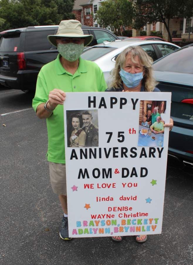 David Starnes, one of the couple's three children, and wife, Linda, hold up the sign they made. (Brian Perdue/Community Impact Newspaper)