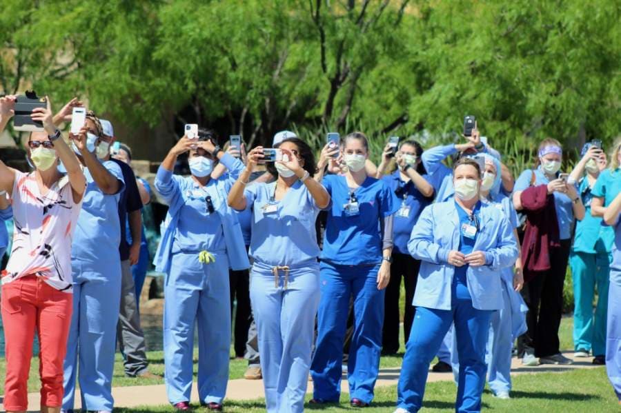 Texas Health Alliance hospital workers look on as the U.S. Navy Blue Angels conduct the America Strong flyover above Northeast Fort Worth. (Ian Pribanic/Community Impact Newspaper)