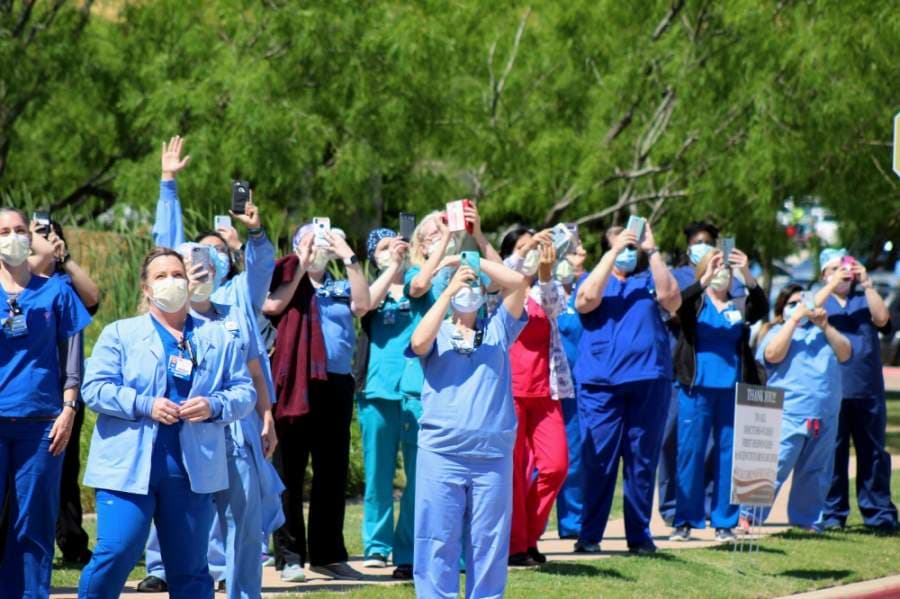 Texas Health Alliance hospital workers look on as the U.S. Navy Blue Angels conduct the America Strong flyover above Northeast Fort Worth. (Ian Pribanic/Community Impact Newspaper)