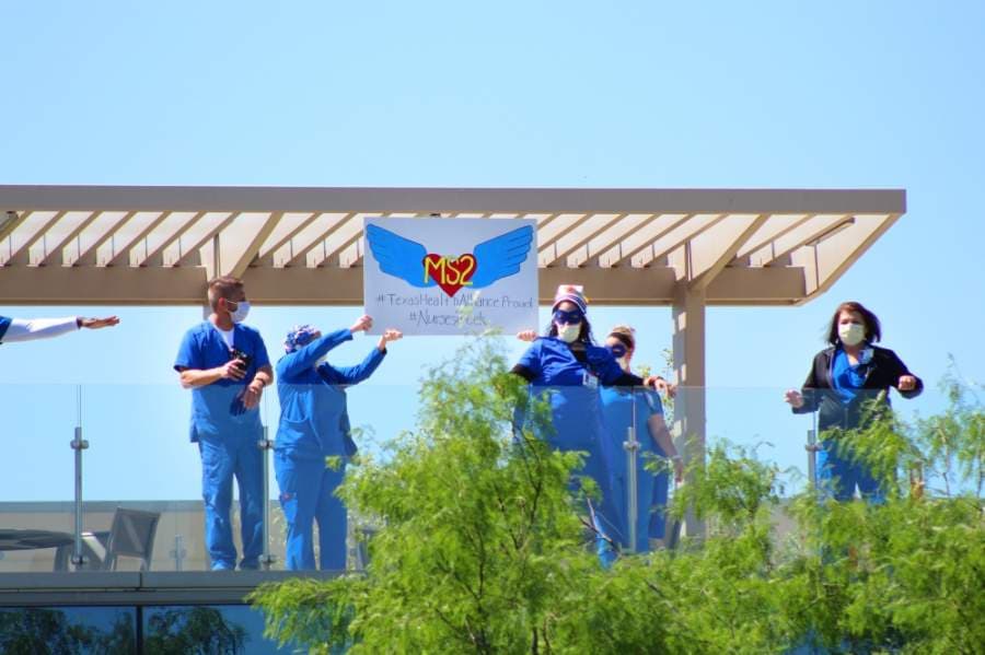 Health care workers lined the sidewalks and tops of buildings at Texas Health Alliance hospital in anticipation of the U.S. Navy Blue Angels. (Ian Pribanic/Community Impact Newspaper)