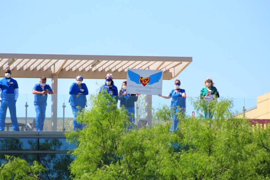 Health care workers lined the sidewalks and tops of buildings at Texas Health Alliance hospital in anticipation of the U.S. Navy Blue Angels. (Ian Pribanic/Community Impact Newspaper)