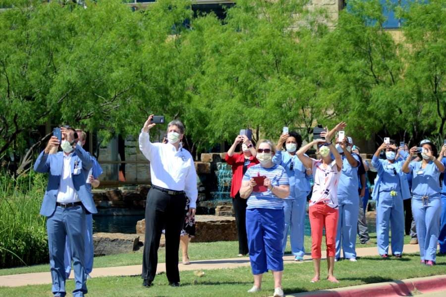 Texas Health Alliance hospital workers look on as the U.S. Navy Blue Angels conduct the America Strong flyover above Northeast Fort Worth. (Ian Pribanic/Community Impact Newspaper)