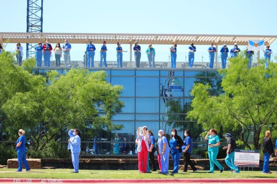 Health care workers lined the sidewalks and tops of buildings at Texas Health Alliance hospital in anticipation of the U.S. Navy Blue Angels. (Ian Pribanic/Community Impact Newspaper)